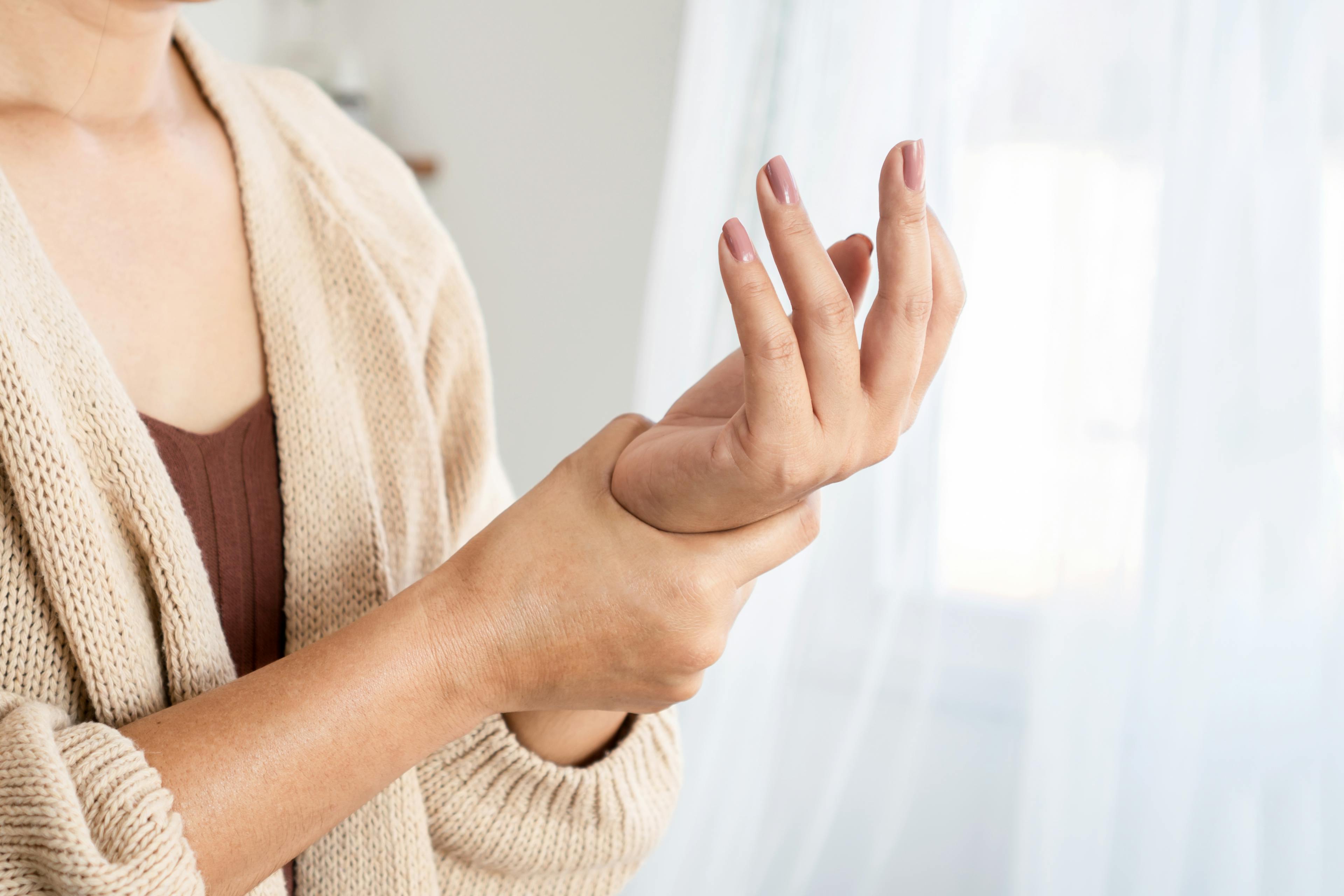 A lady holding her wrist due to experiencing gout