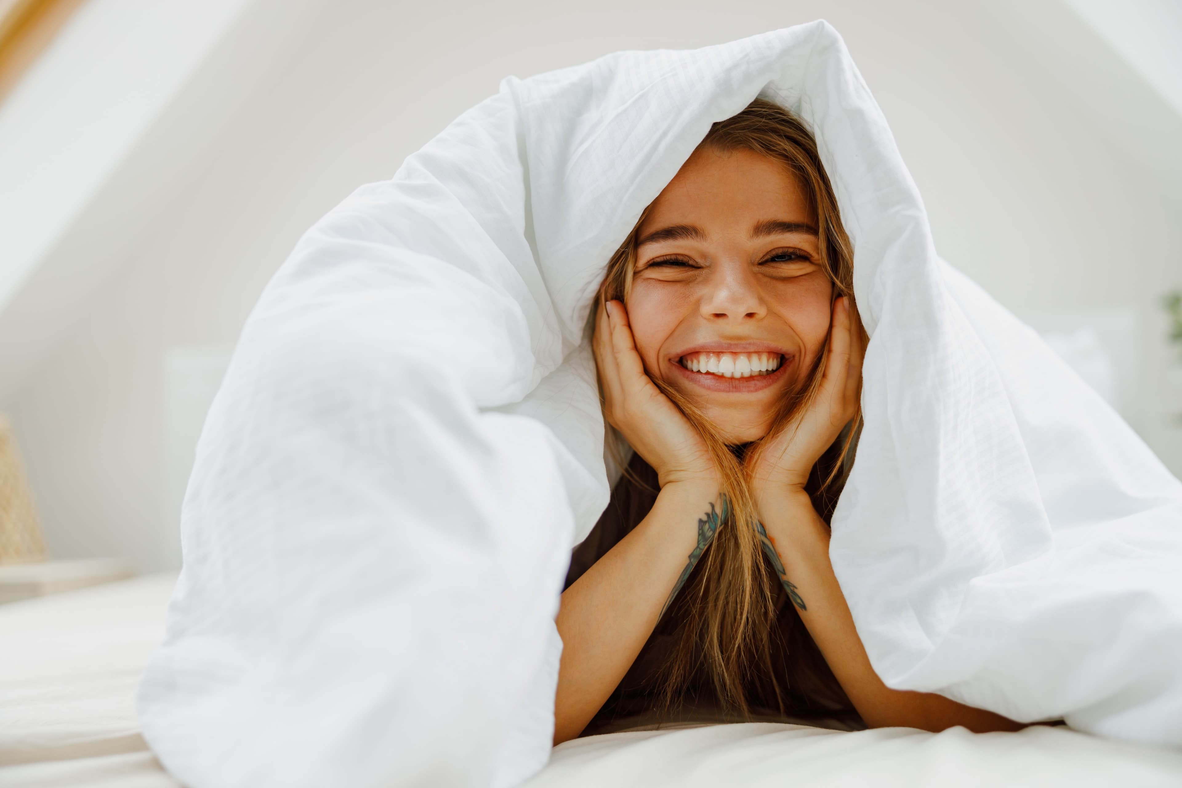 A lady relaxing under her bed cover